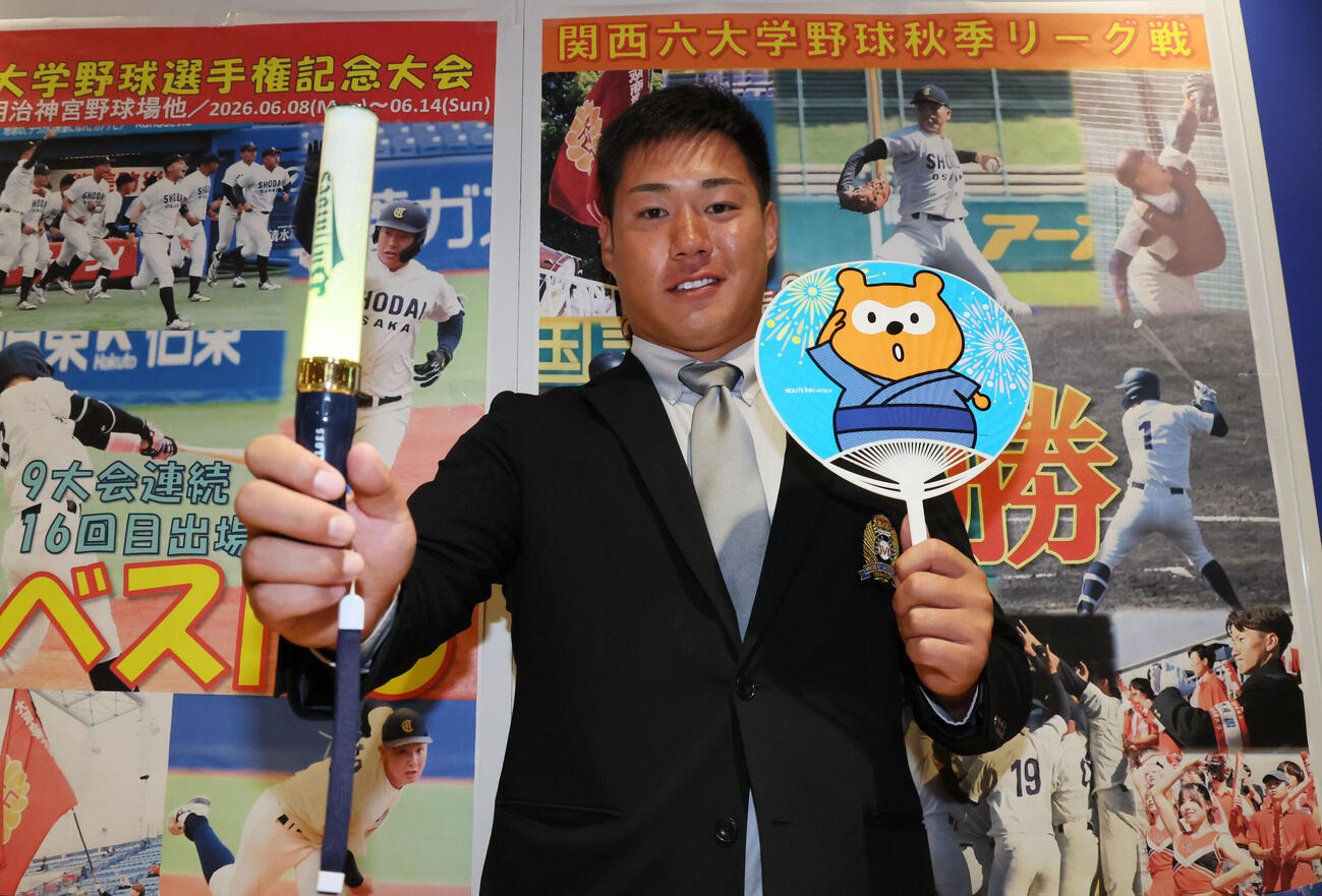 オリックスからドラフト3位指名された春山陽登は、球団グッズを手に笑顔を見せる（撮影・宮崎幸一）