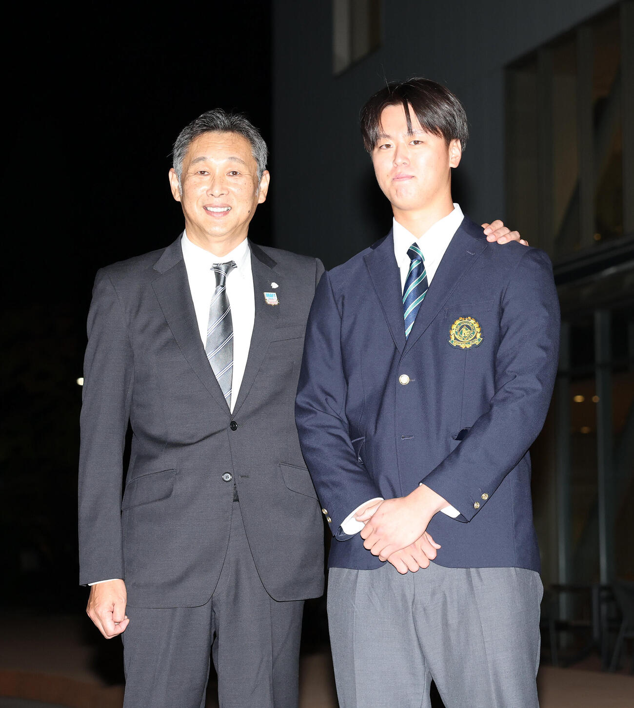 西武西口文也監督に肩を抱かれるドラフト1位の亜大・川尻啓人（撮影・鈴木正人）