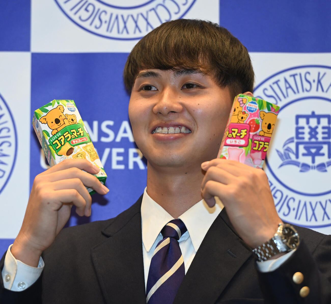 笑顔でロッテ「コアラのマーチ」を手にする関大・米沢友翔（撮影・和賀正仁）