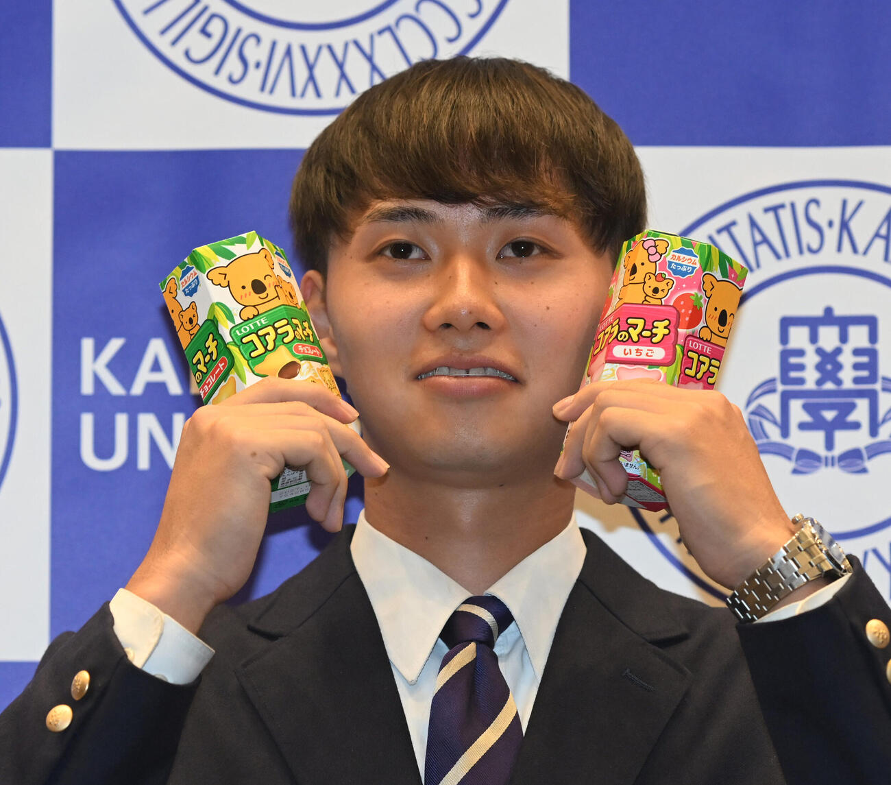 笑顔でロッテ「コアラのマーチ」を手にする関大・米沢友翔（撮影・和賀正仁）