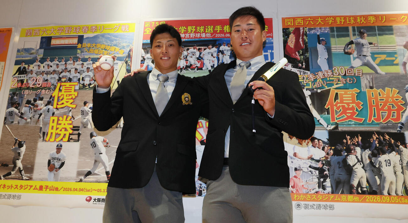 DeNAからドラフト1位指名を受けた大商大・星野世那（左）とオリックスからドラフト3位指名された春山陽登は、それぞれの球団グッズを手に笑顔を見せる（撮影・宮崎幸一）