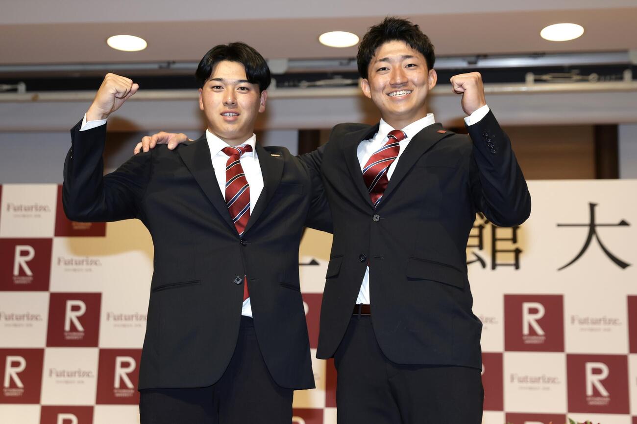 笑顔でガッツポーズする、ソフトバンクから2位指名を受けた立命大・有馬伽久（左）と広島から2位指名を受けた西野啓也（撮影・前田充）
