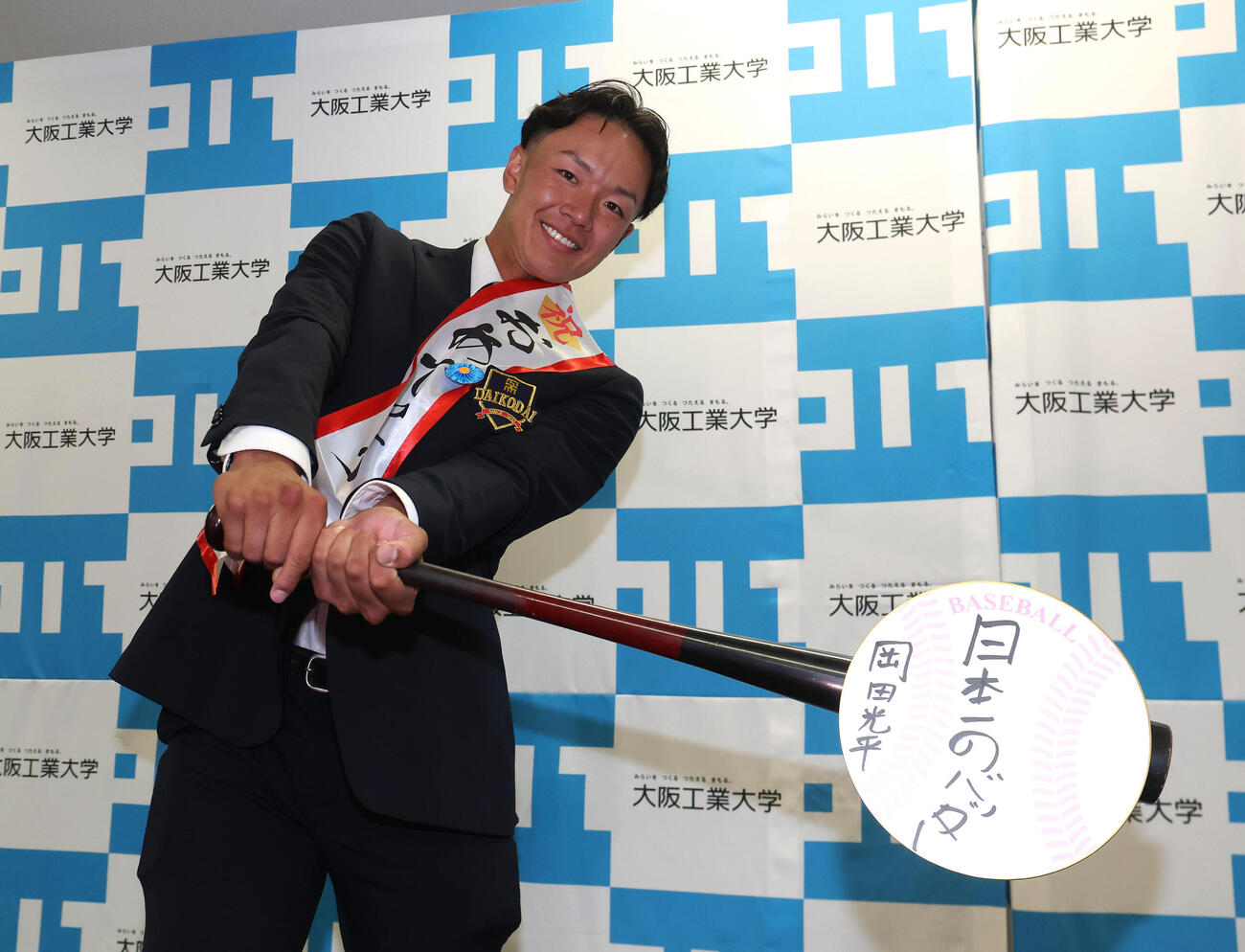 日本一のバッターと目標に書いた色紙をフルスイングする日本ハムから育成1位の指名を受けた大工大・岡田光平（撮影・白石智彦）