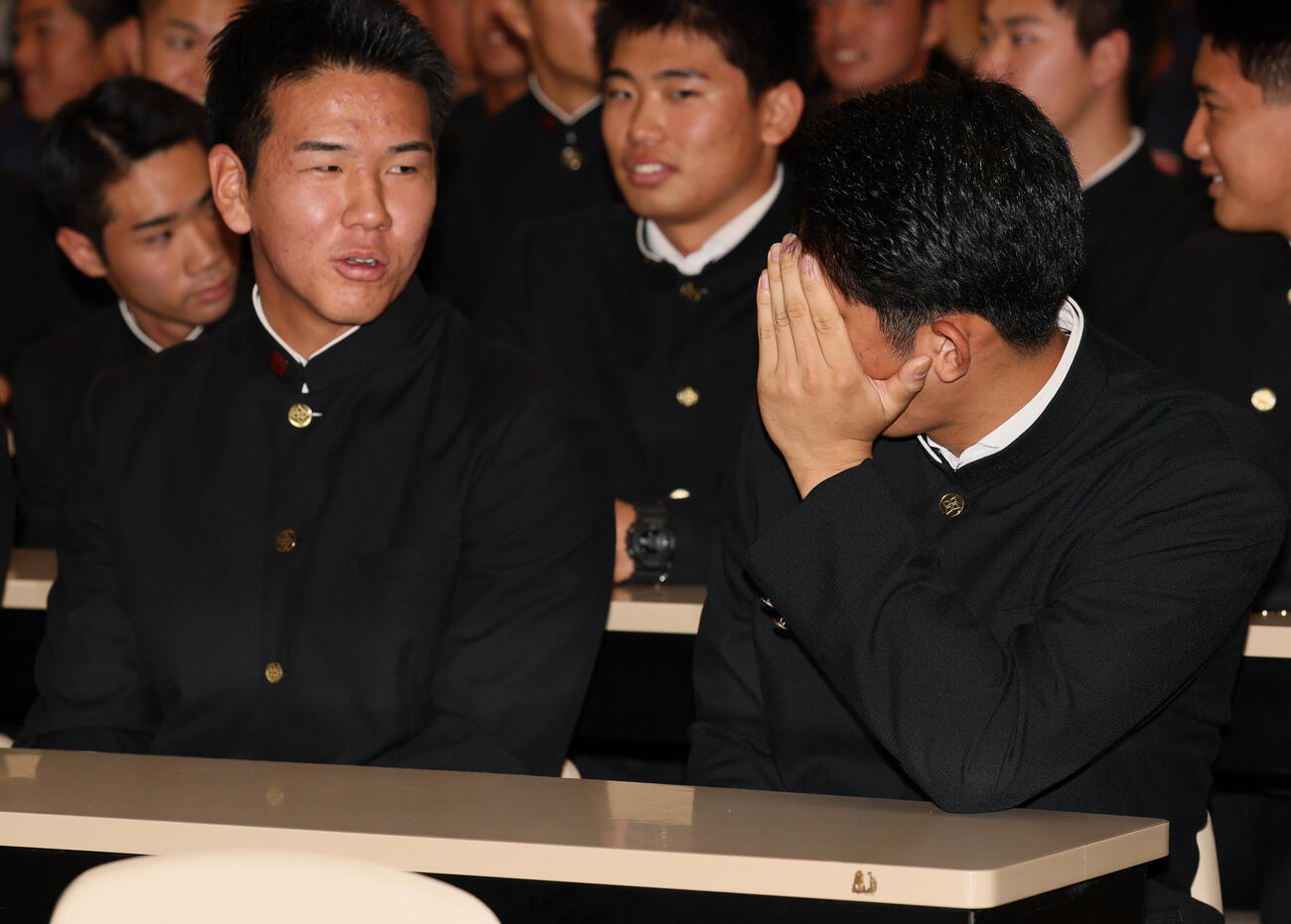 巨人からドラフト1位指名を受けた横浜・織田翔希（右）は顔を隠してチームメートと談笑（撮影・水谷安孝）