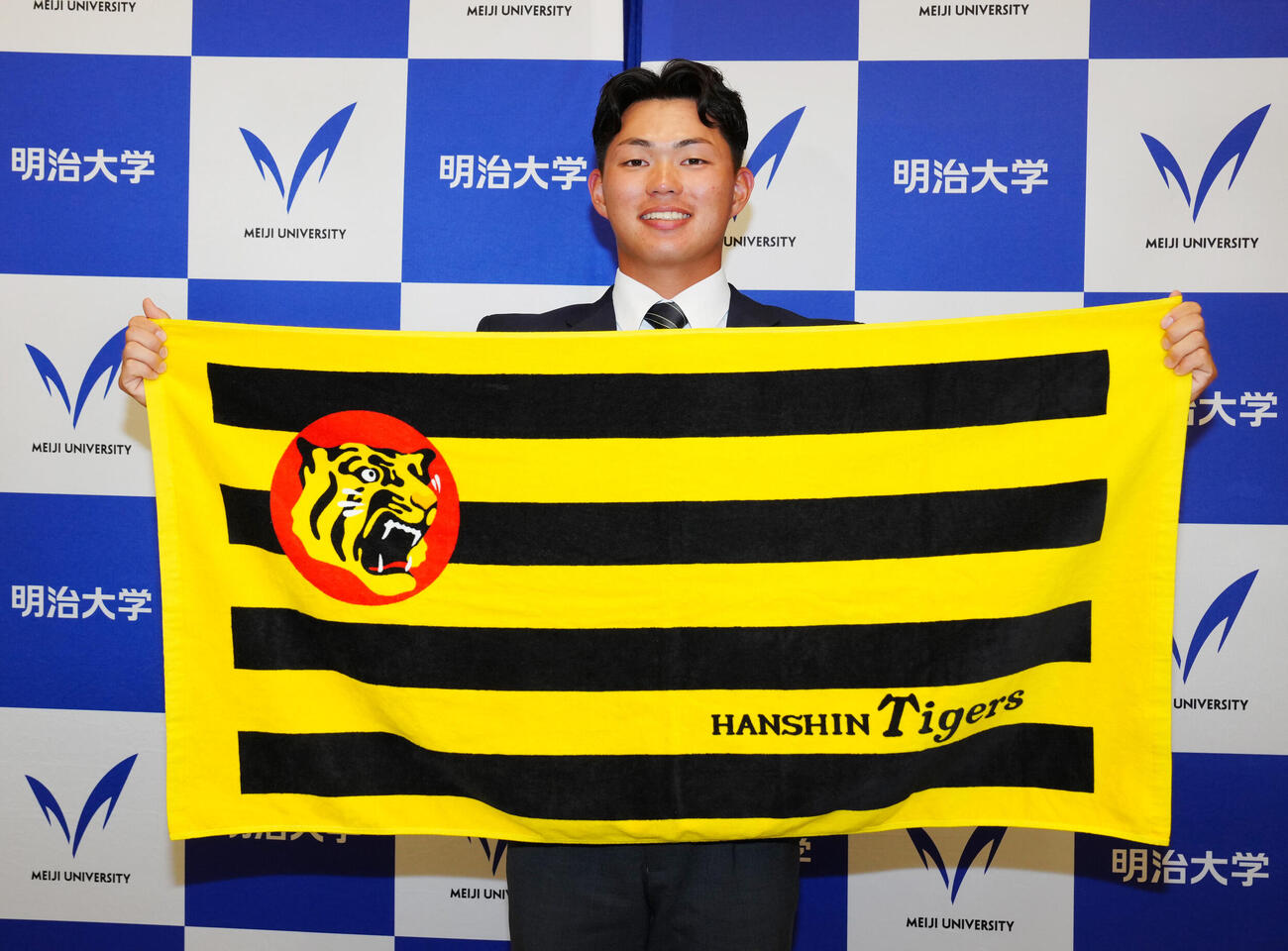 阪神1位指名を受け、写真に納まる明大・榊原七斗（撮影・江口和貴）