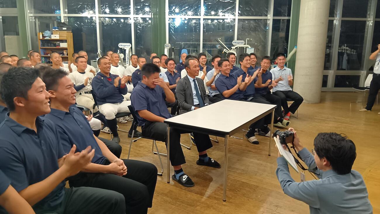 東京・町田の日大三高野球部寮で、西武から4位指名を受けた直後に目頭を押さえる田中と笑顔の三木監督（右）