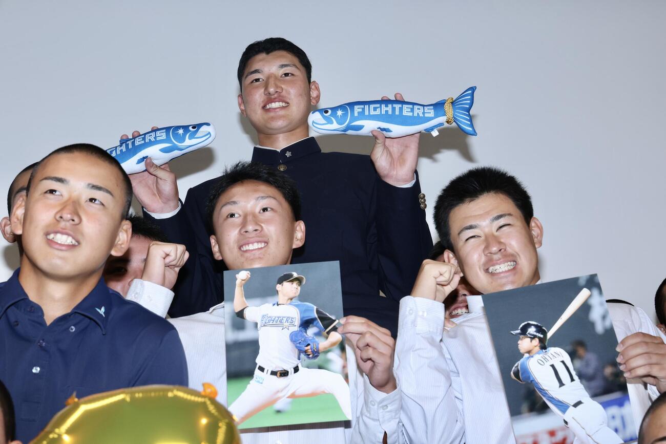 チームメートから騎馬で祝福を受けながら写真に納まる日本ハムから1位指名を受けた山梨学院・菰田陽生（中央上）（撮影・河田真司）