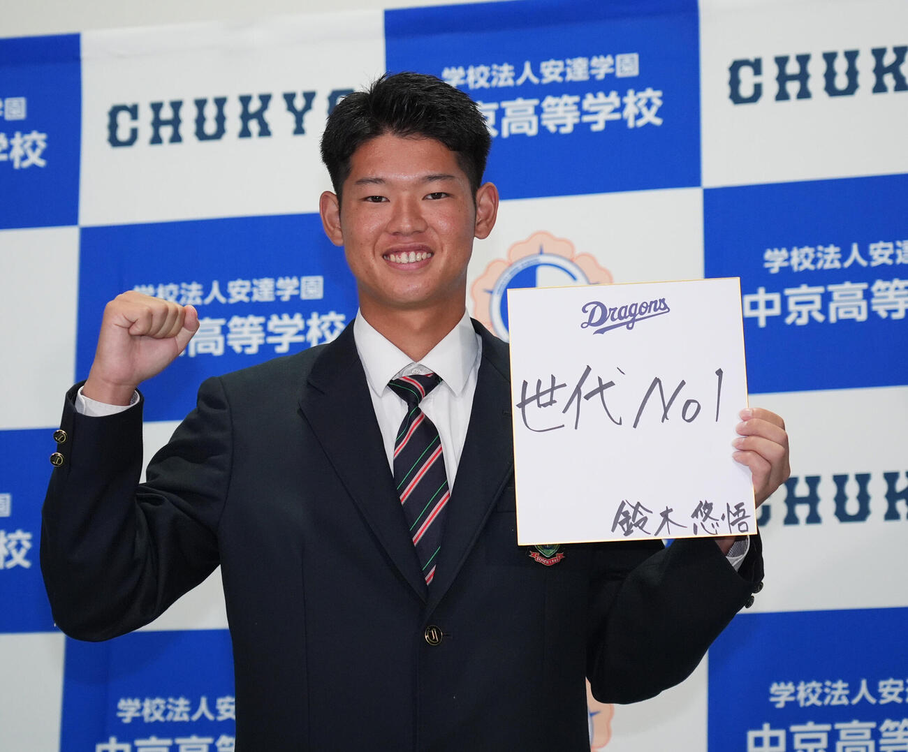中日から4位指名を受け、目標を色紙に記しポーズを決める中京高・鈴木悠悟（撮影・森本幸一）