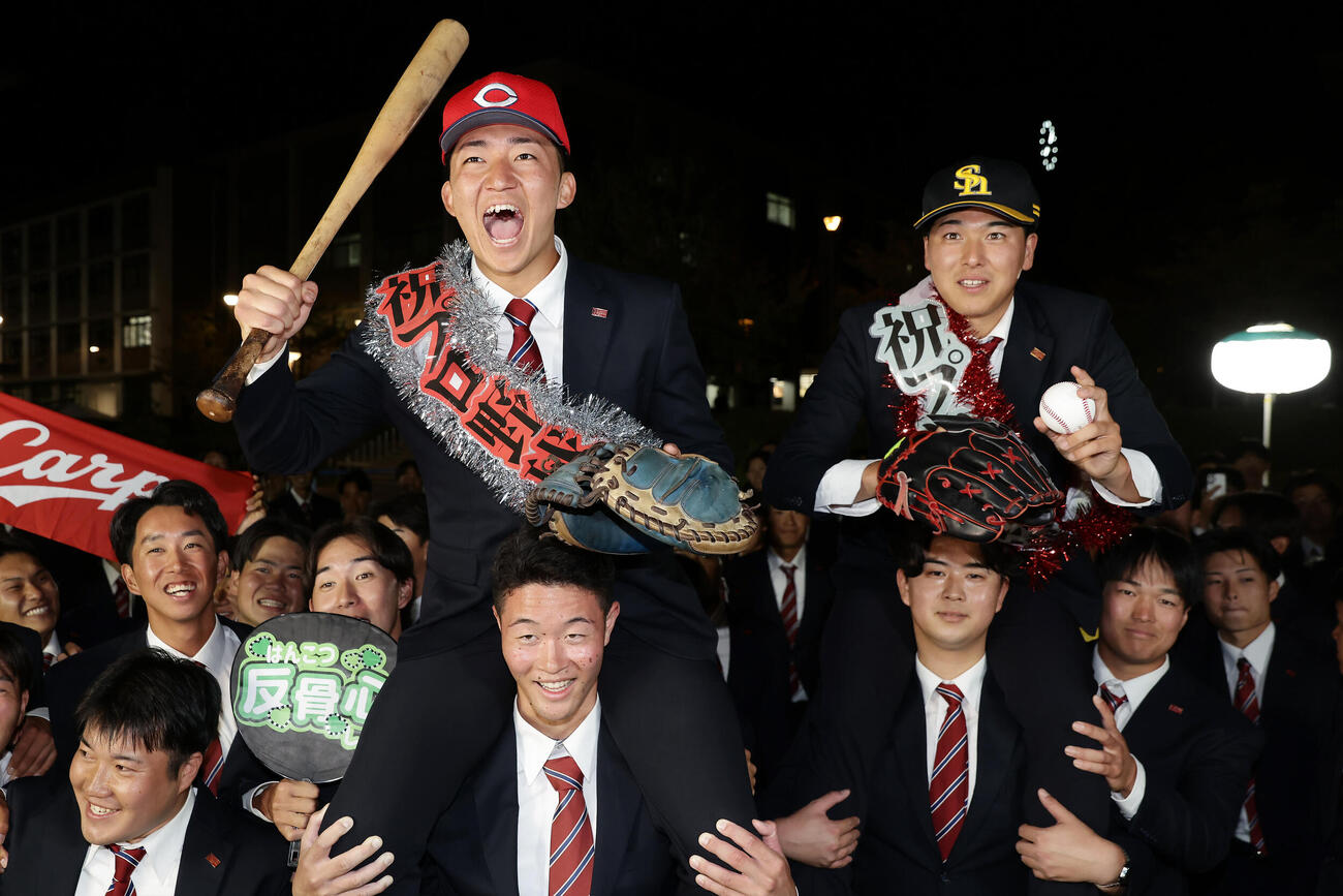 チームメートに担がれ祝福される、広島から2位指名を受けた立命大・西野啓也（左）とソフトバンクから2位指名を受けた有馬伽久（撮影・前田充）