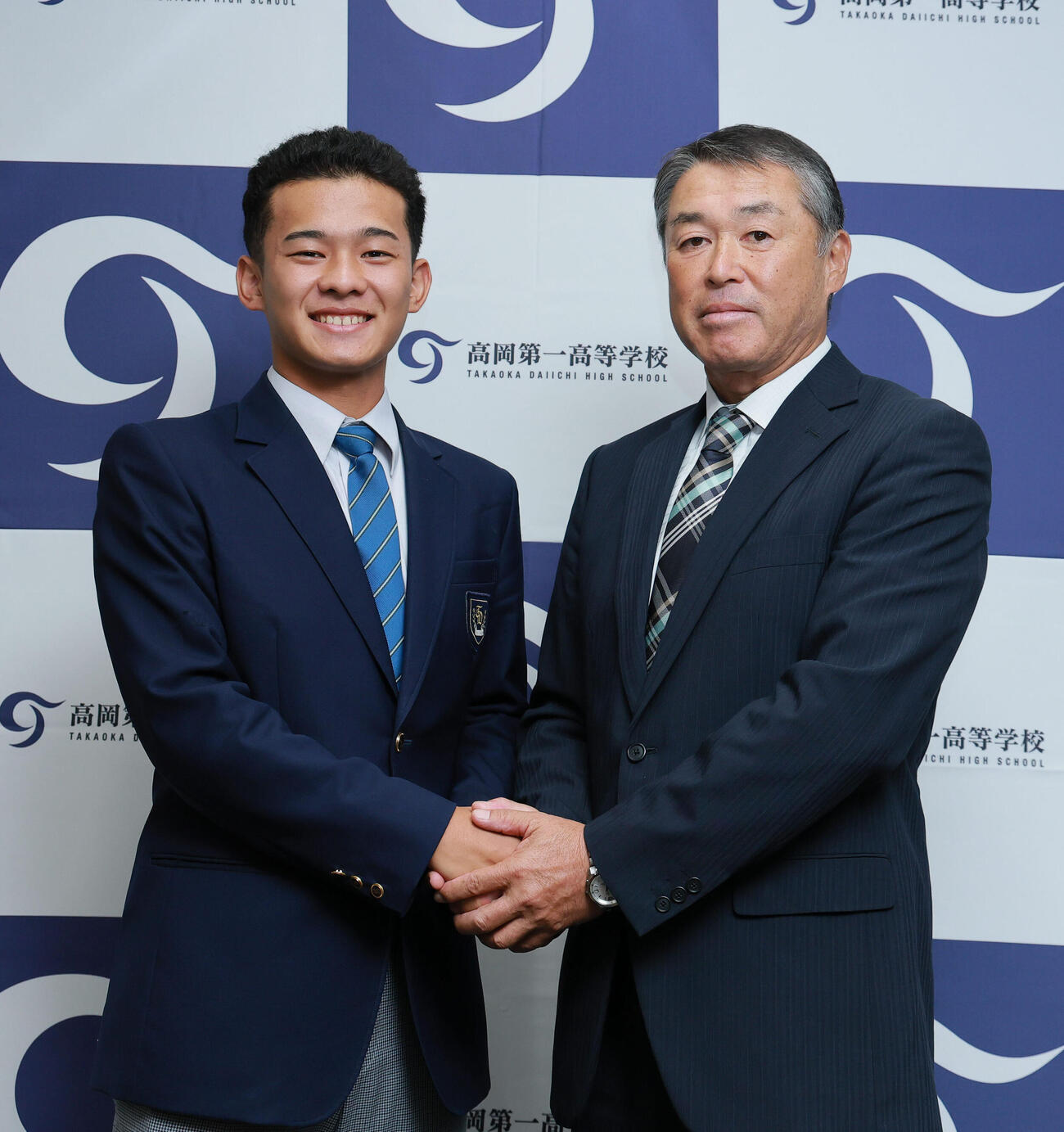 ロッテ2位指名を受けた高岡第一・前田侑大（左）は村本忠秀監督と握手をかわし笑顔を見せる（撮影・上山淳一）