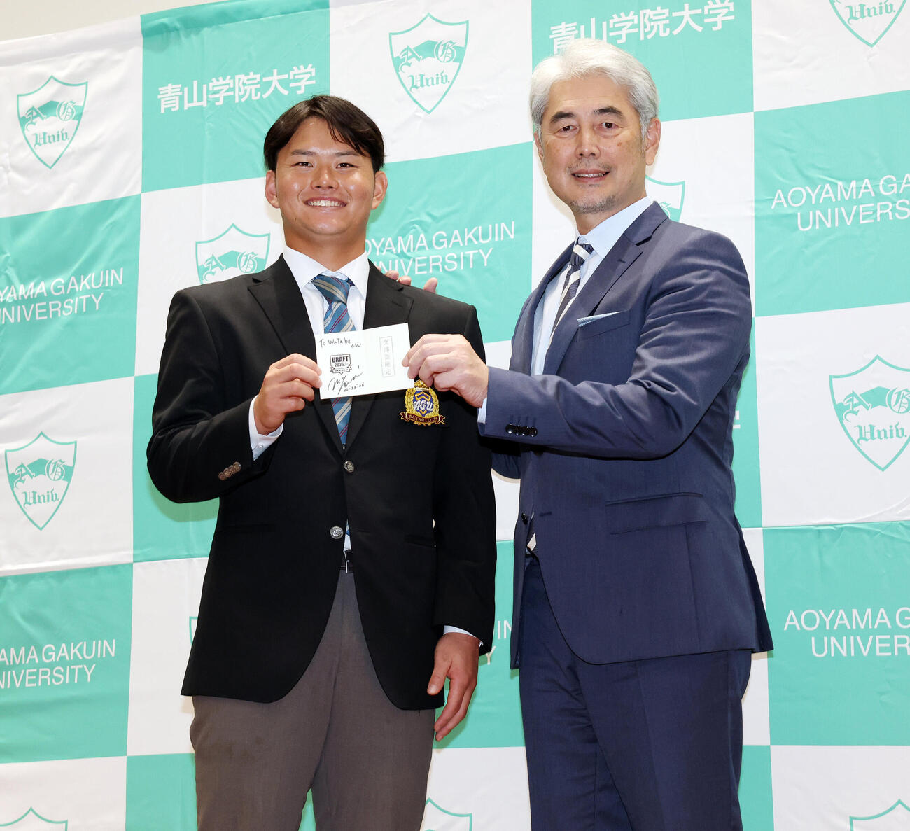 楽天吉井理人監督（右）のサインが書かれた交渉権確定の印が押されたくじを手に笑顔で記念撮影するドラフト1位青学大・渡部海（撮影・宮地輝）