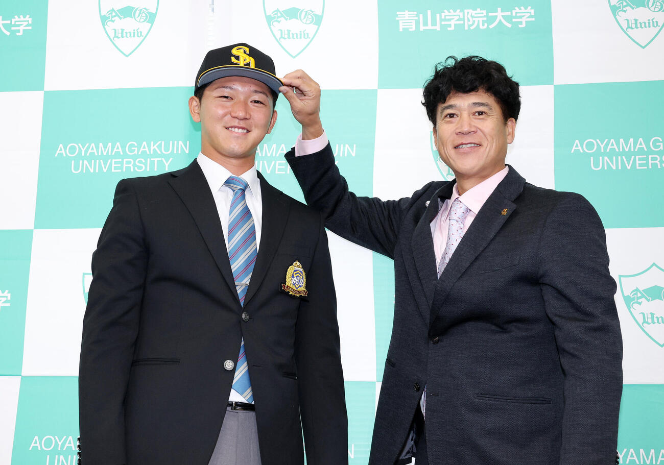 笑顔で写真に納まるソフトバンクドラフト1位の青学大・鈴木泰成（左）と城島健司CBO（撮影・鈴木正人）