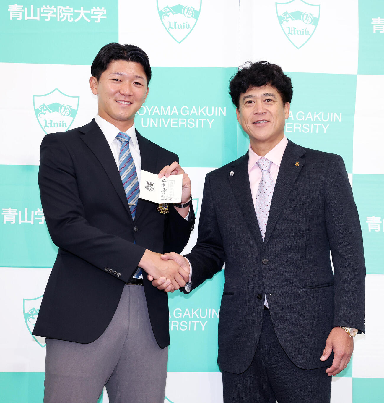 交渉権確定の紙を手に笑顔を見せるソフトバンク1位の青学大・鈴木泰成（左）と城島健司CBO（撮影・鈴木正人）