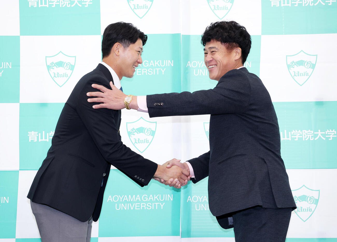 笑顔で握手するソフトバンクドラフト1位の青学大・鈴木泰成（左）と城島健司CBO（撮影・鈴木正人）
