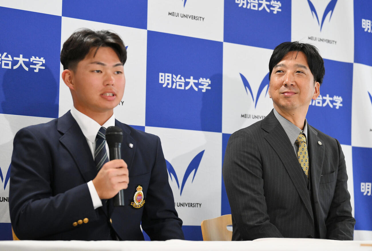 指名あいさつを受け会見する阪神ドラフト1位の明大・榊原七斗（左）を見守る藤川球児監督（撮影・滝沢徹郎）