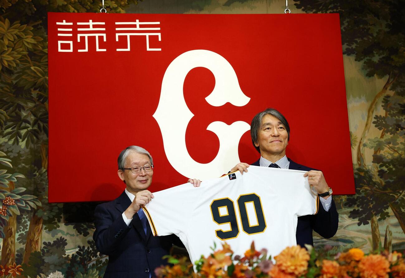 背番号「90」のユニフォームを手に笑顔を見せる巨人松井秀喜新監督（右）。左は山口オーナー（ロイター）