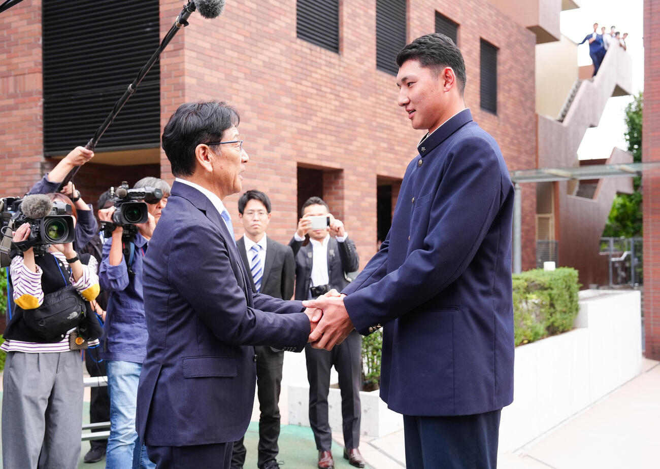 日本ハムドラフト1位の山梨学院・菰田陽生（右）は指名あいさつに訪れた栗山英樹CBOと握手（撮影・鈴木みどり）