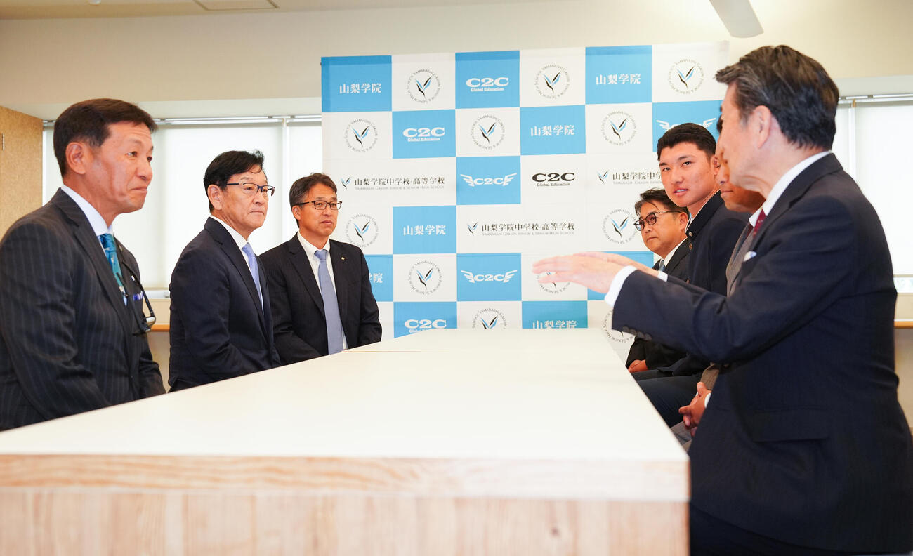 日本ハムドラフト1位の山梨学院・菰田陽生（左から5人目）は指名あいさつに訪れた栗山英樹CBO（同2人目）らと談笑（撮影・鈴木みどり）