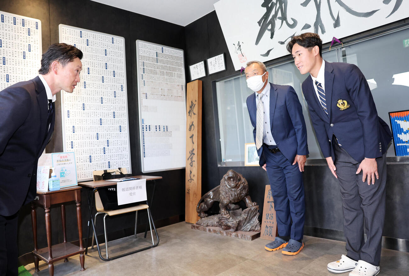 指名あいさつに訪れたオリックス岸田護監督（左）と出迎えるドラフト2位の駒大・仲井慎（撮影・鈴木正人）