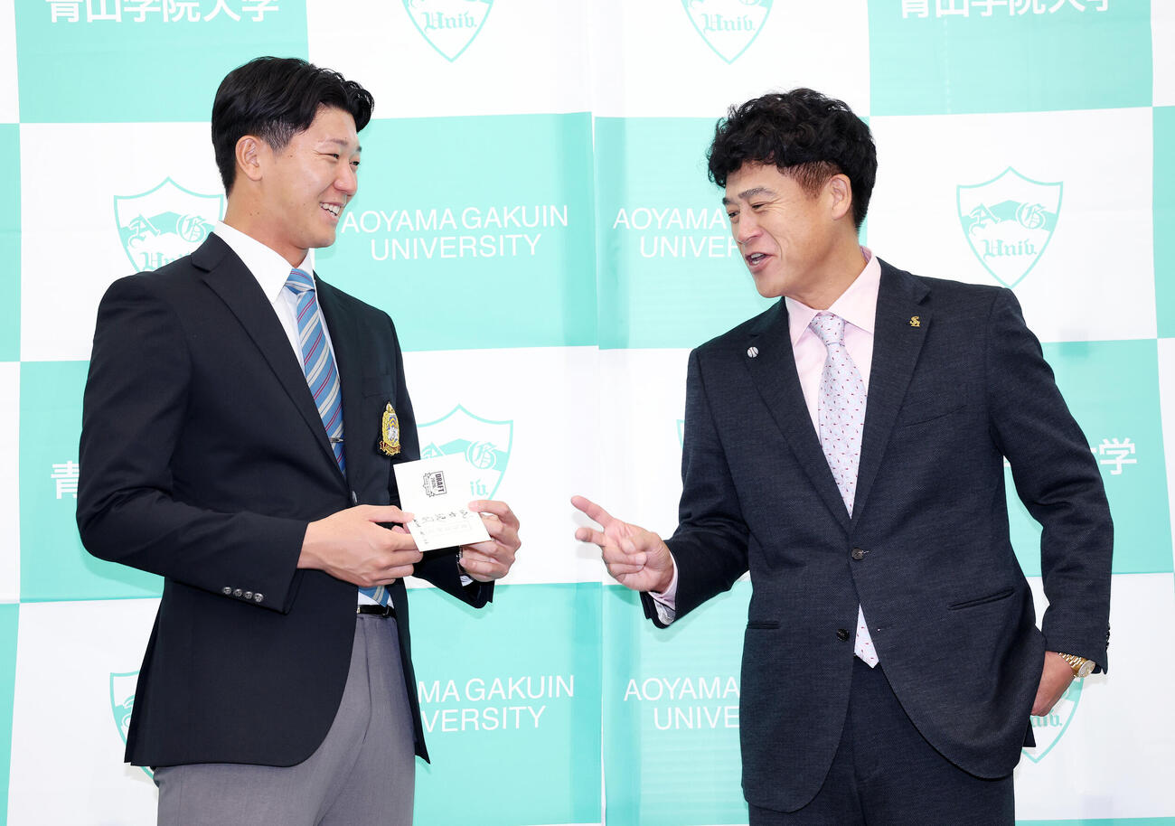 ソフトバンク城島健司CBO（右）から交渉権確定の紙を受け取るドラフト1位の青学大・鈴木泰成（撮影・鈴木正人）