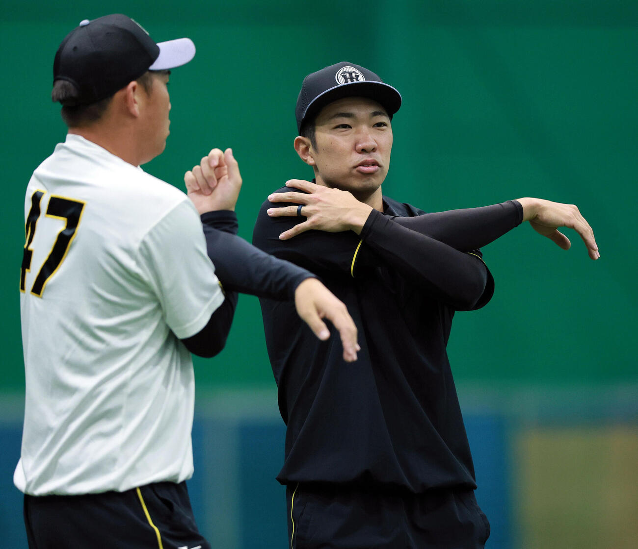 室内で体を動かす阪神石井大智（右）と桐敷拓馬（撮影・上山淳一）
