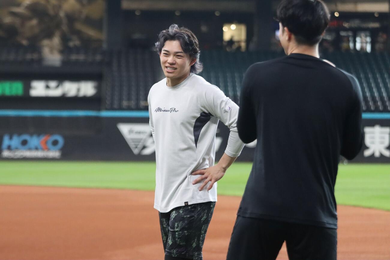 郡司と談笑する日本ハム田宮（左）