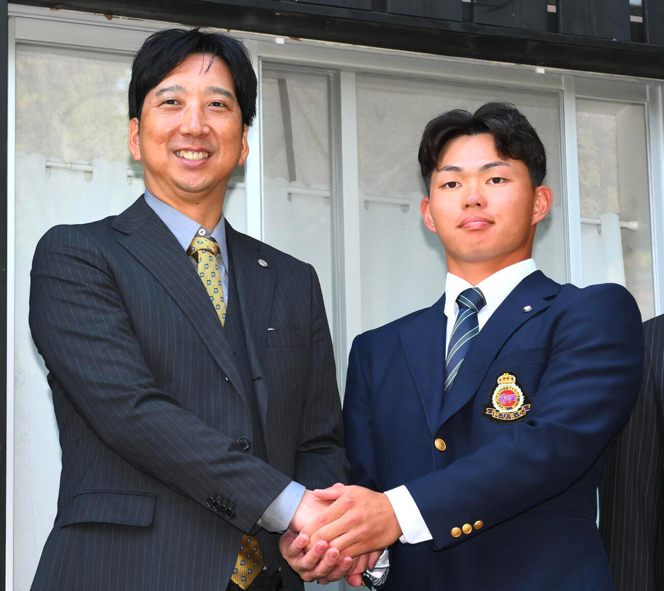 23日、阪神藤川監督（左）と握手を交わすドラフト1位の明大・榊原七斗