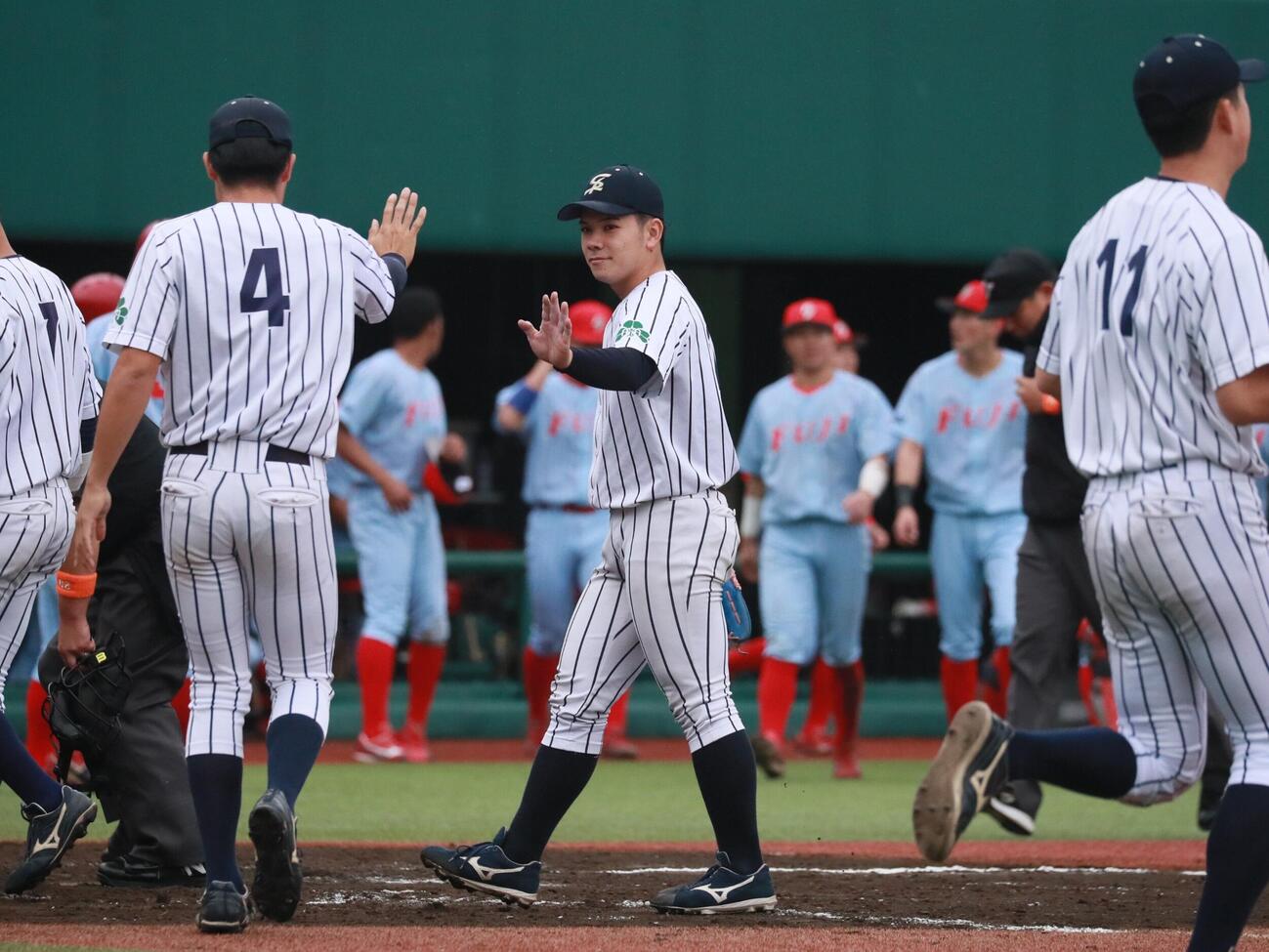 仙台大対富士大　完封勝利し、チームメートとハイタッチをする仙台大・大城海翔投手（中央）（撮影・高橋香奈）