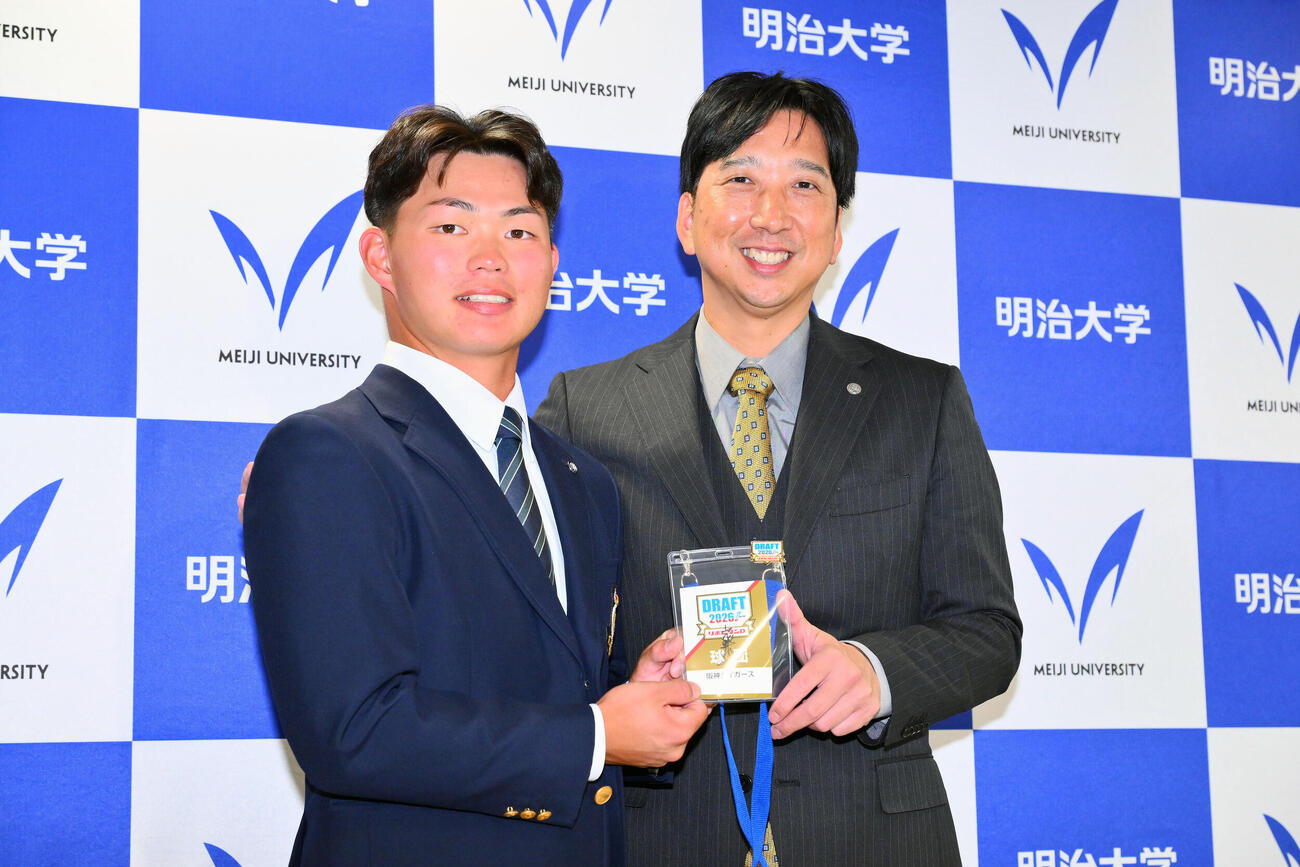 23日、指名あいさつを受けた阪神ドラフト1位の明大・榊原七斗（左）はドラフト会議のサイン入りのパスを手に藤川球児監督と記念撮影する
