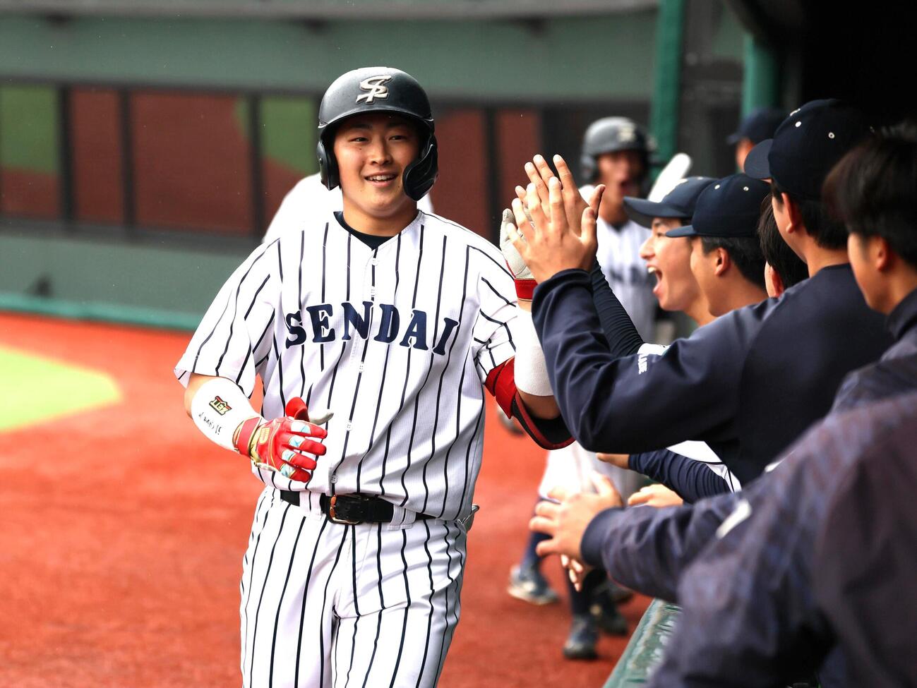 東日本国際大対仙台大　1回2死満塁で本塁打を放ちベンチに祝福を受ける仙台大・井尻琉斗捕手