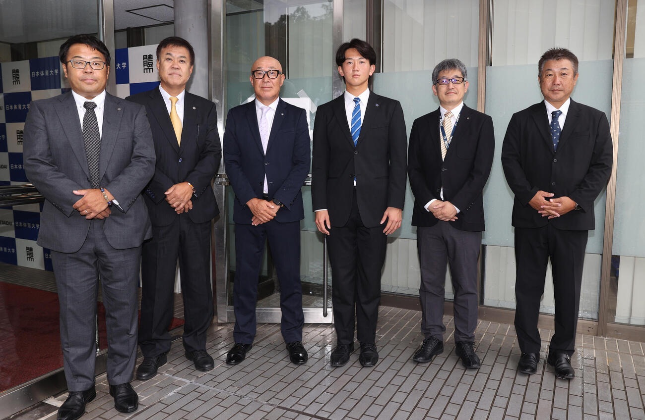指名あいさつに訪れ記念撮影に納まる。左から阪神の東辰弥編成ディレクター、平塚克洋スカウト、畑山俊二統括スカウト、2位指名の日体大・馬場拓海、大石健二部長、古城隆利監督（撮影・柴田隆二）