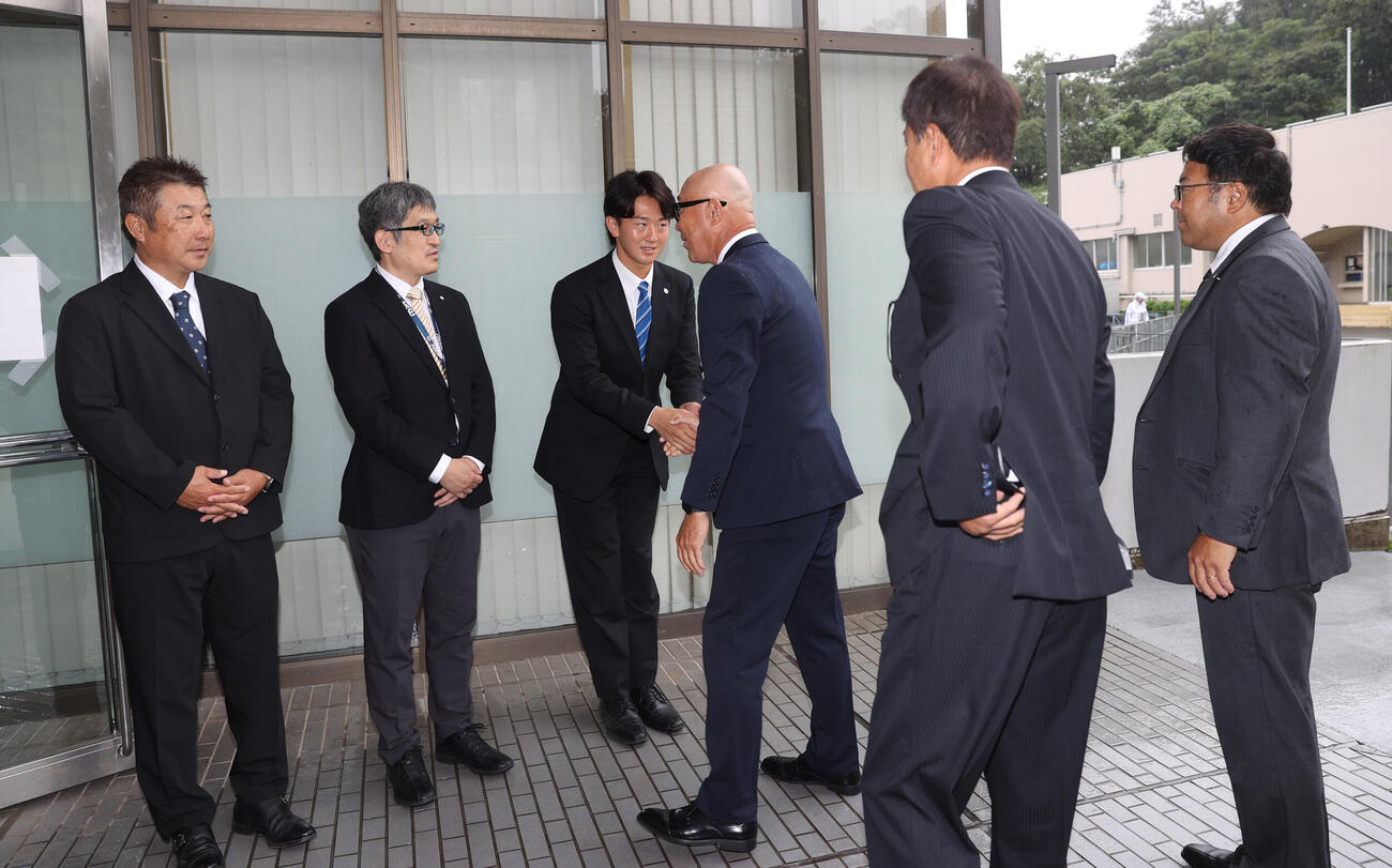 左から日体大野球部の古城隆利監督、大石健二部長、2位指名の日体大・馬場拓海は阪神の畑山俊二統括スカウト、平塚克洋スカウト、東辰弥編成ディレクターから指名あいさつを受ける（撮影・柴田隆二）
