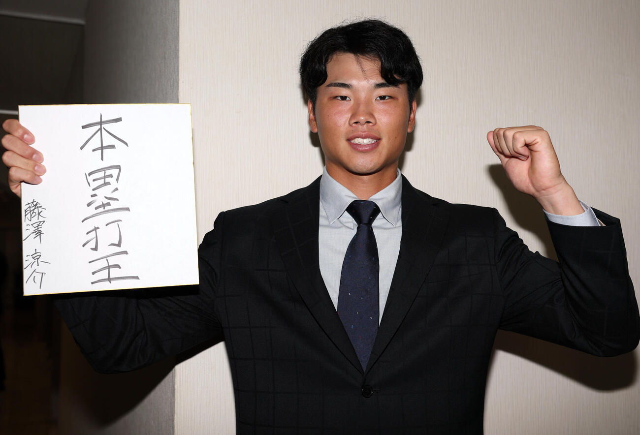 ヤクルトの指名あいさつを受けた東京ガスの藤沢涼介は色紙に「本塁打王」と抱負を書いてガッツポーズ（撮影・浅見桂子）
