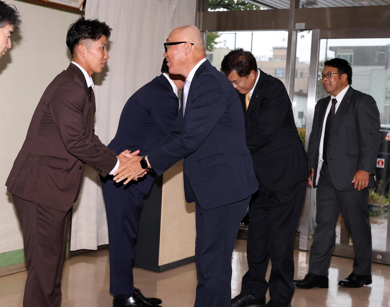 阪神指名あいさつを受けた東京ガスの越川海翔（左）は、畑山統括スカウトらを出迎え握手する（撮影・浅見桂子）