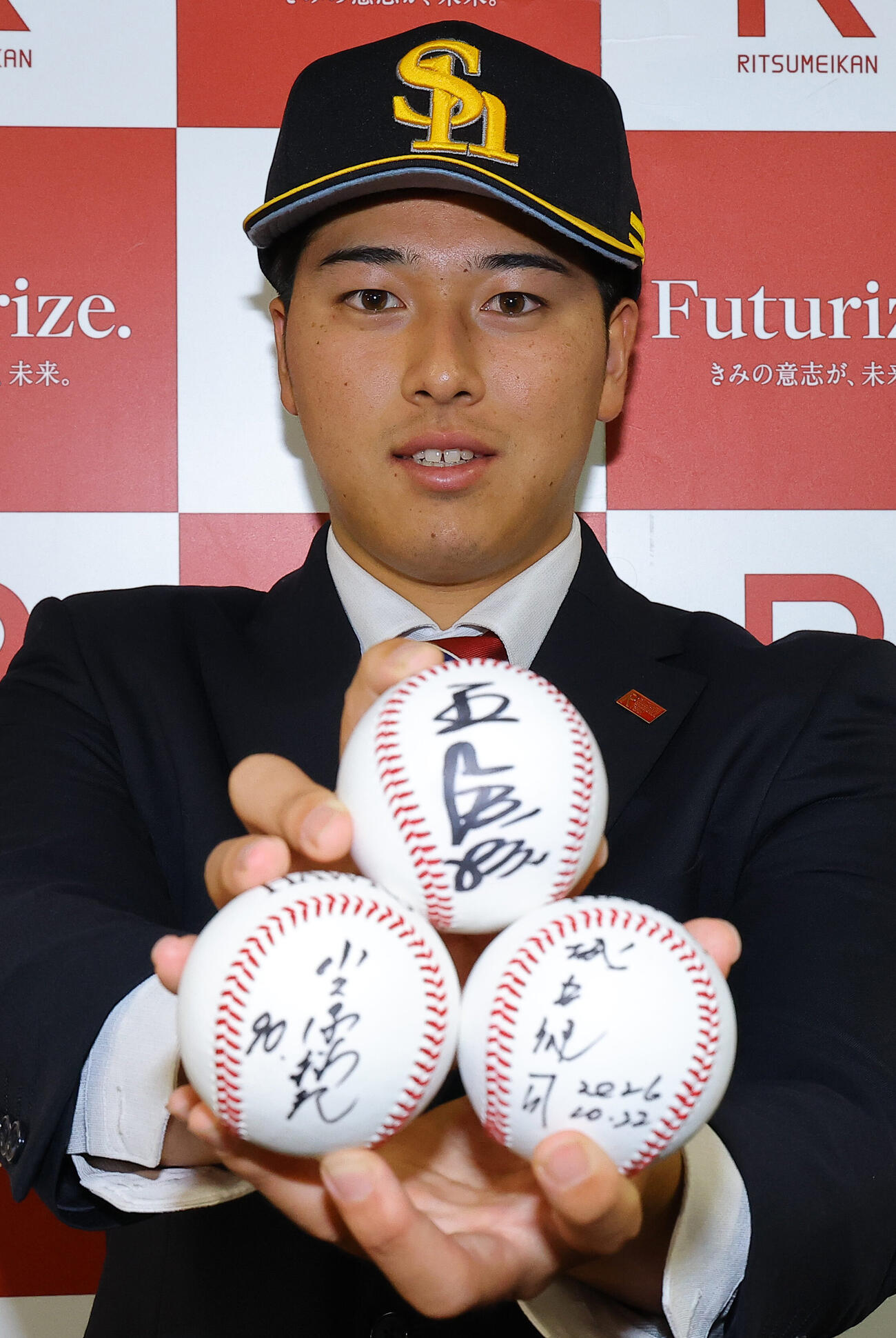 指名あいさつを受けたソフトバンクドラフト2位の立命大・有馬伽久は王貞治球団会長、小久保裕紀監督、城島健司CBOのサインボールを手に笑顔を見せる（撮影・上田博志）