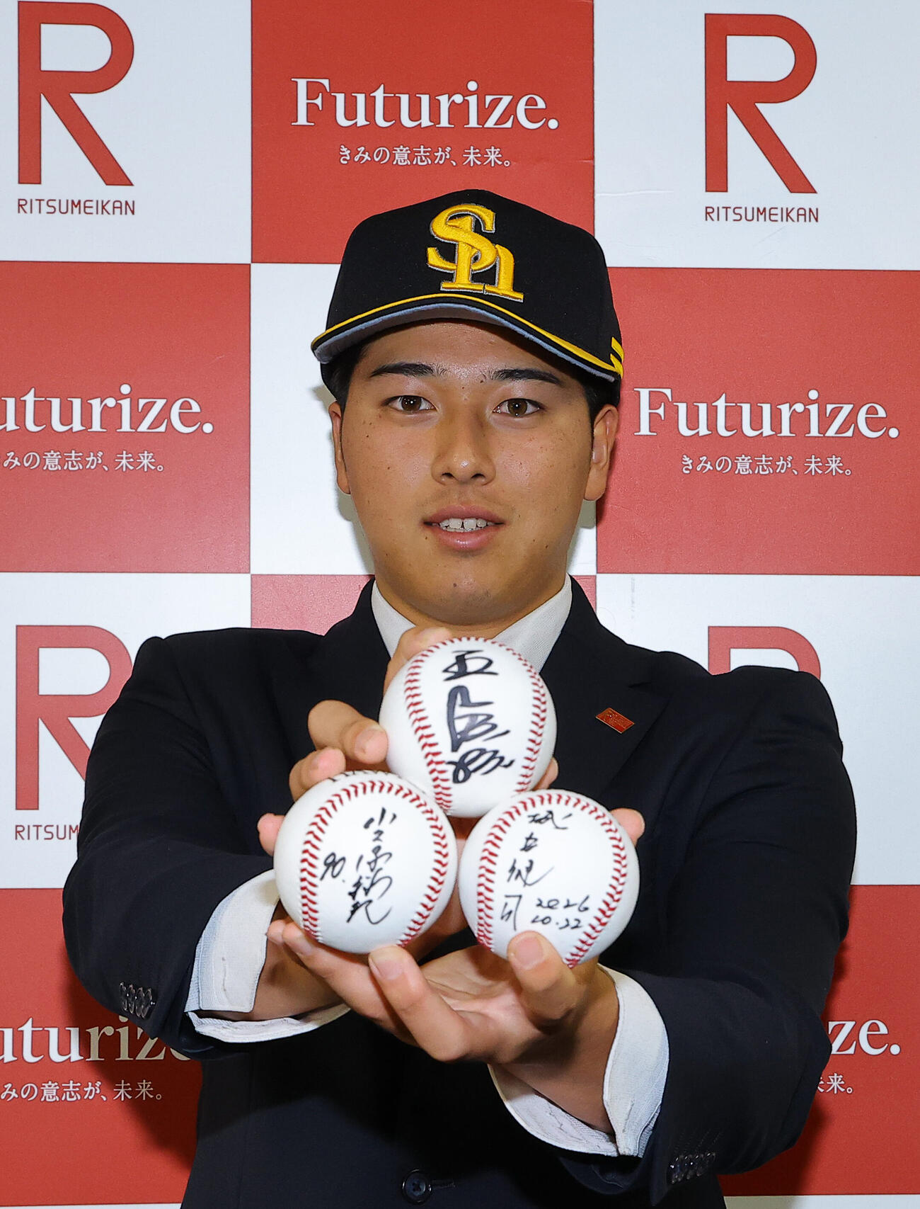 指名あいさつを受けたソフトバンクドラフト2位の立命大・有馬伽久は王貞治球団会長、小久保裕紀監督、城島健司CBOのサインボールを手に笑顔を見せる（撮影・上田博志）
