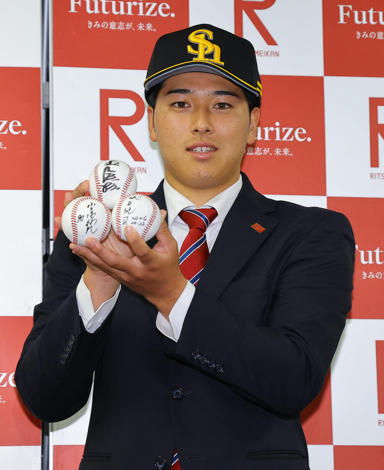 指名あいさつを受けたソフトバンクドラフト2位の立命大・有馬伽久は王貞治球団会長、小久保裕紀監督、城島健司CBOのサインボールを手に笑顔を見せる（撮影・上田博志）