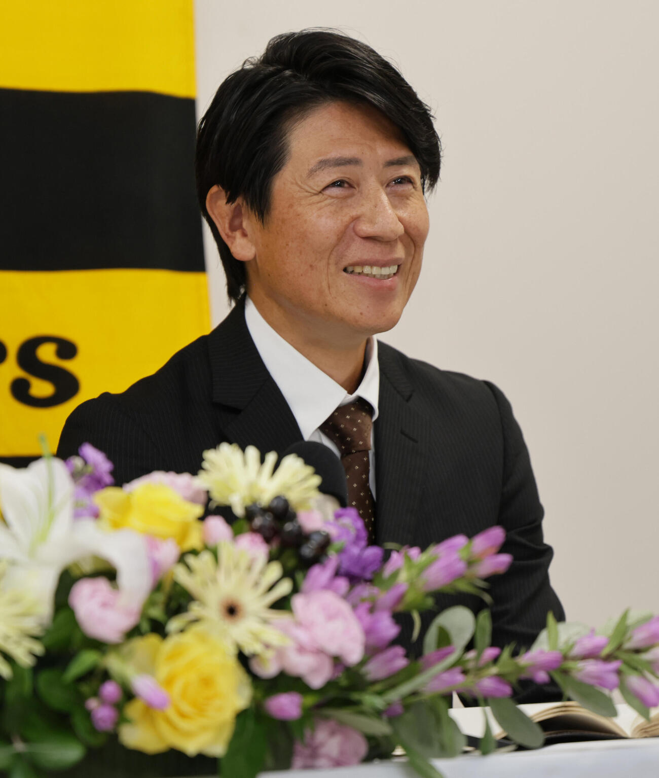 阪神の2軍打撃コーチに就任した的場寛一氏は笑顔を見せる（撮影・宮崎幸一）