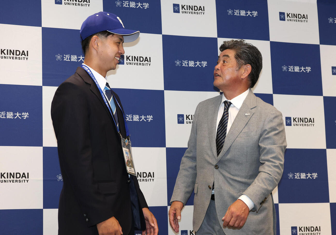 中日ドラフト1位の近大・宮原廉（左）に帽子を被せて見つめる工藤公康監督（撮影・白石智彦）