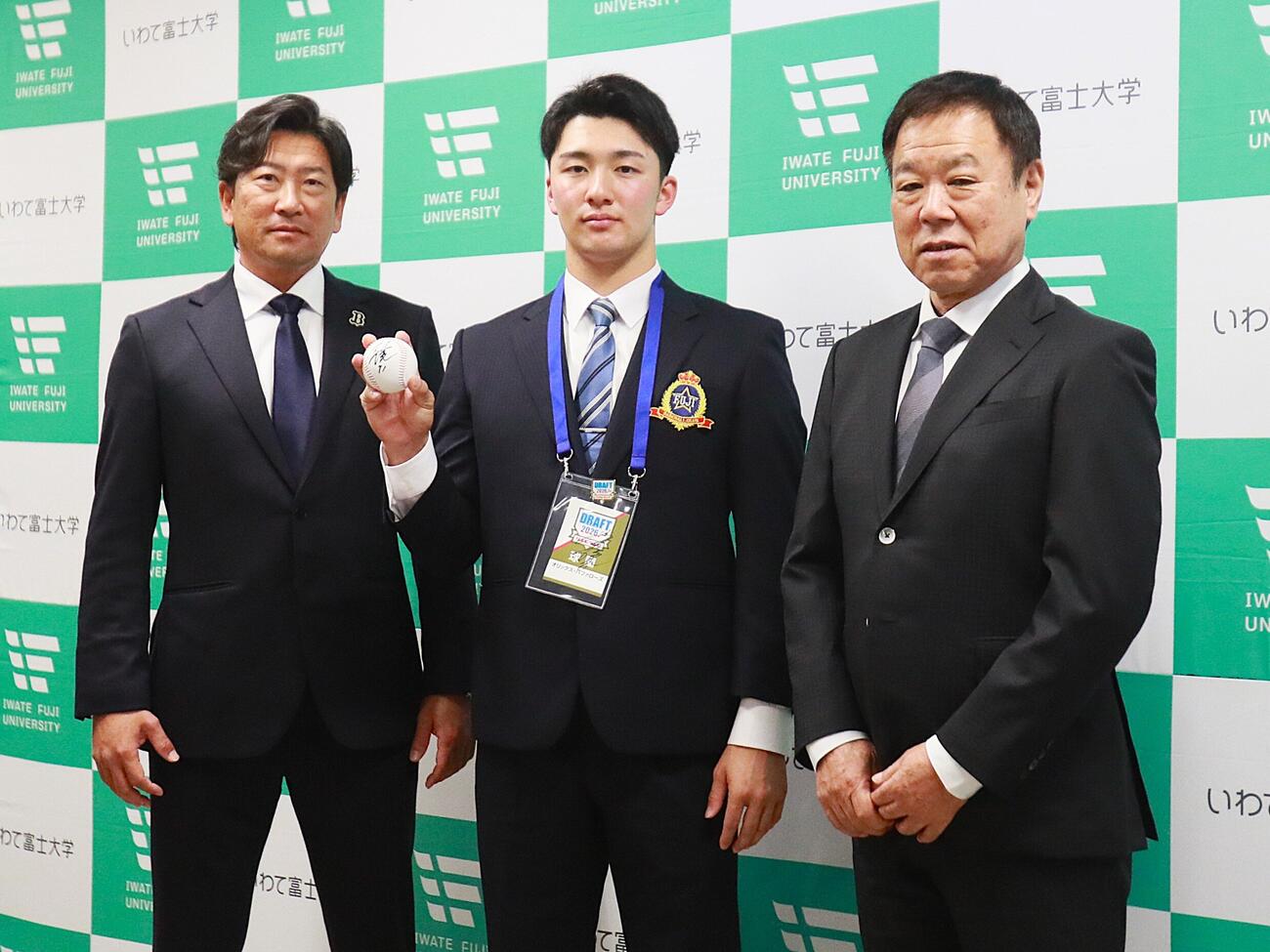 指名あいさつを受けた富士大・角田楓斗投手（中央）は福良淳一GM（右）と小松聖スカウトと写真撮影（撮影・高橋香奈）