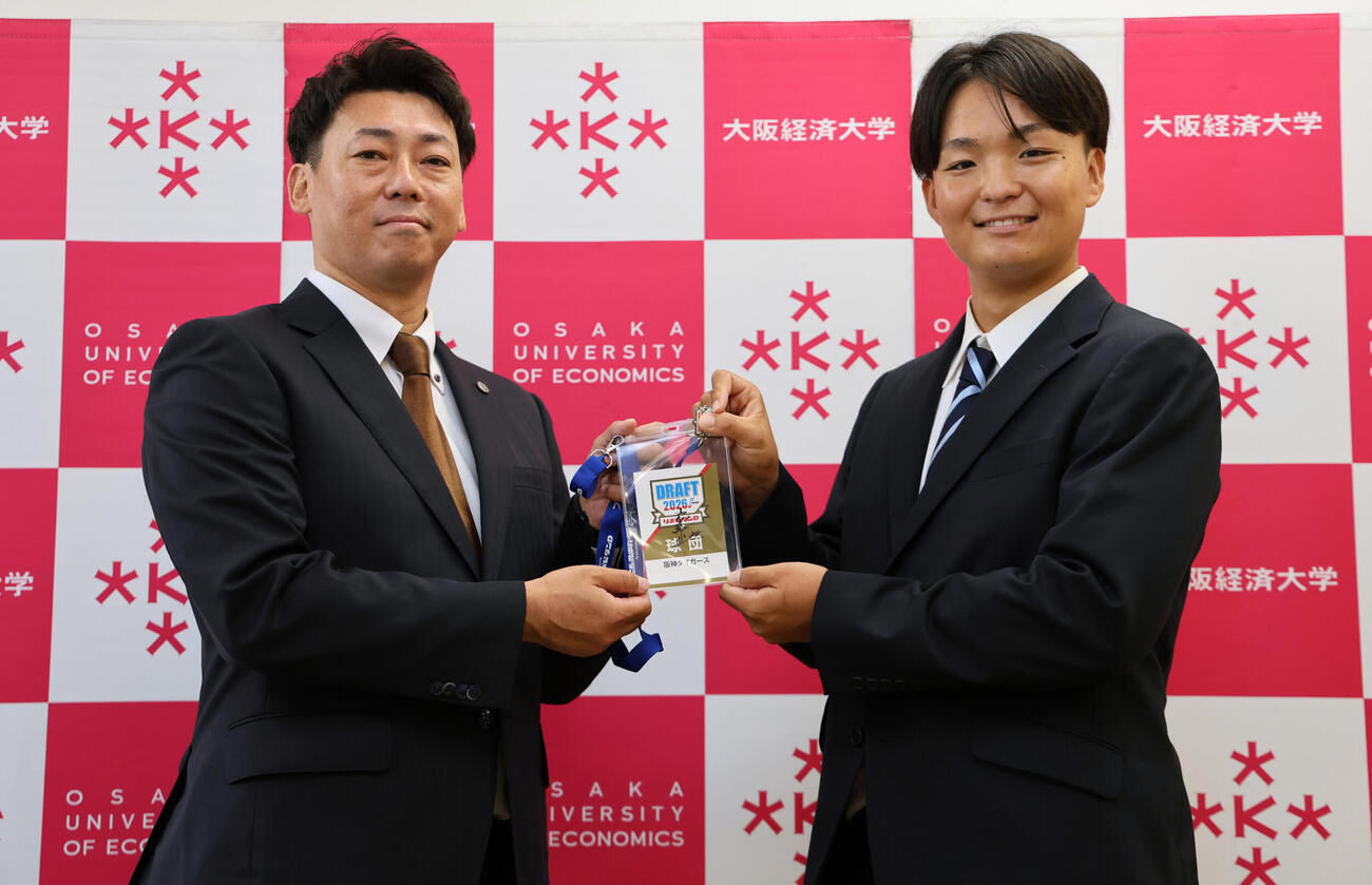 阪神ドラフト3位の大経大・常深颯大（右）は、岡本スカウトから藤川球児監督のサインが入ったドラフト会議のパスを受け取る（撮影・宮崎幸一）
