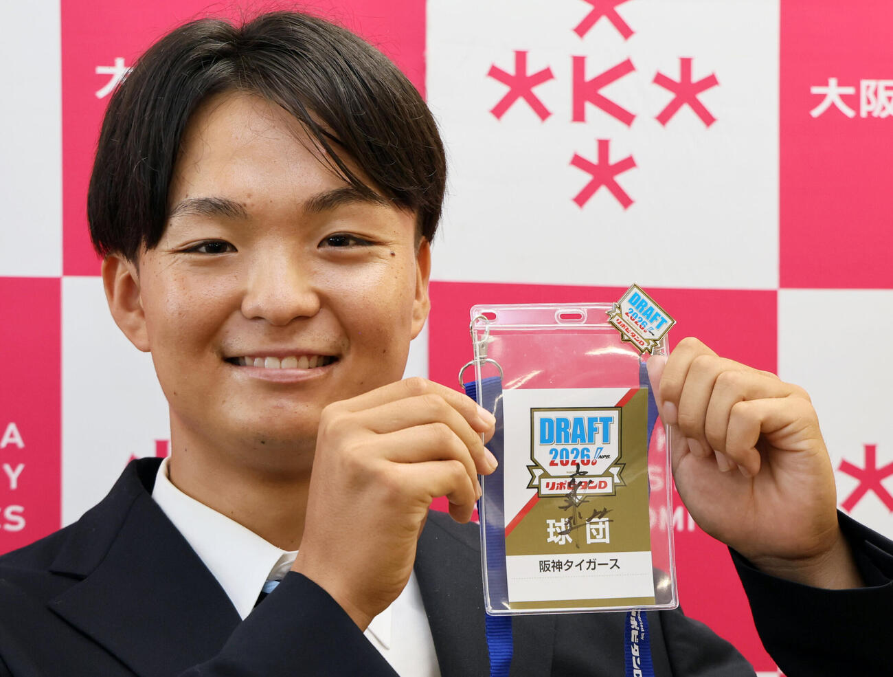 阪神ドラフト3位の大経大・常深颯大は、藤川球児監督のサインが入ったドラフト会議のパスを手に笑顔を見せる（撮影・宮崎幸一）