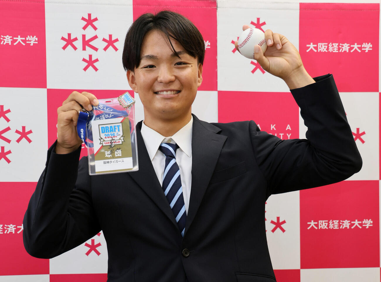阪神ドラフト3位の大経大・常深颯大は、藤川球児監督のサインが入ったドラフト会議のパスとボールを手に笑顔を見せる（撮影・宮崎幸一）