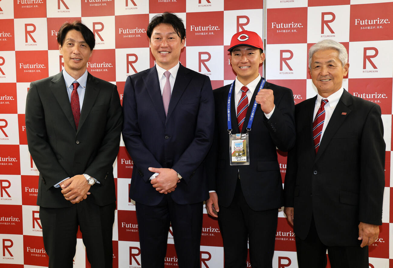 広島新井貴浩監督（左）の指名あいさつを受けた立命大・西野啓也は、広島の帽子をかぶり笑顔を見せる。左は鞘師智也スカウト、右は立命大・片山正之監督（撮影・宮崎幸一）