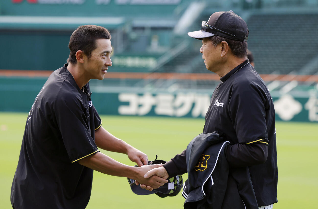 練習前、熊谷敬宥（左）と握手を交わす阪神平田勝男新ヘッドコーチ（撮影・前田充）