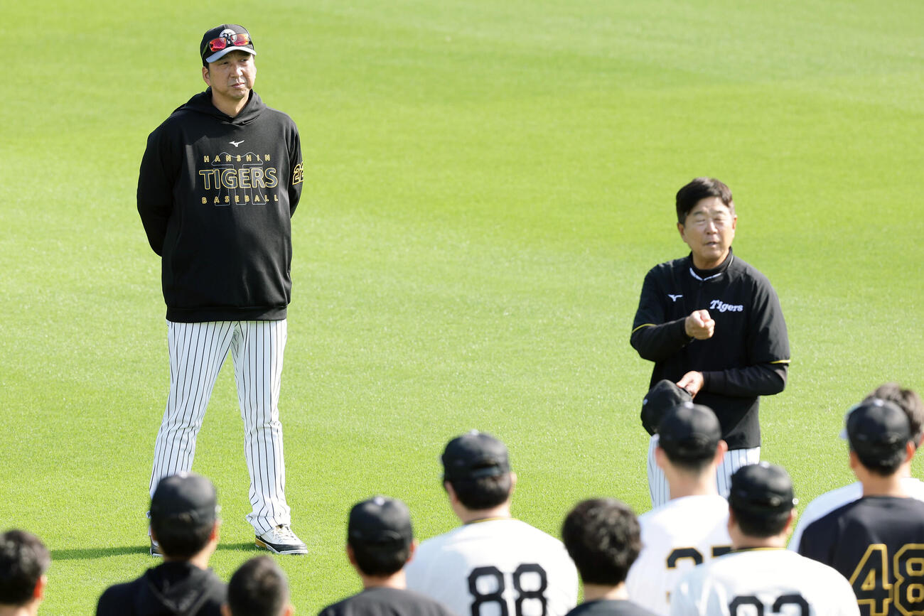 練習前、選手らに話をする平田勝男新ヘッドコーチ（右）を見つめる阪神藤川球児監督（撮影・前田充）