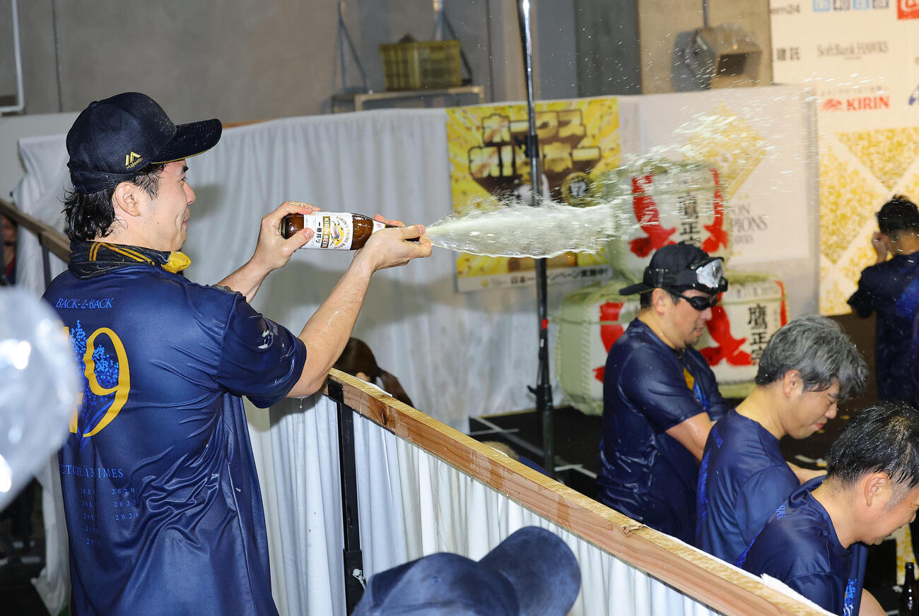 祝勝会で幕外からビールをかけるソフトバンク松本晴（撮影・上田博志）