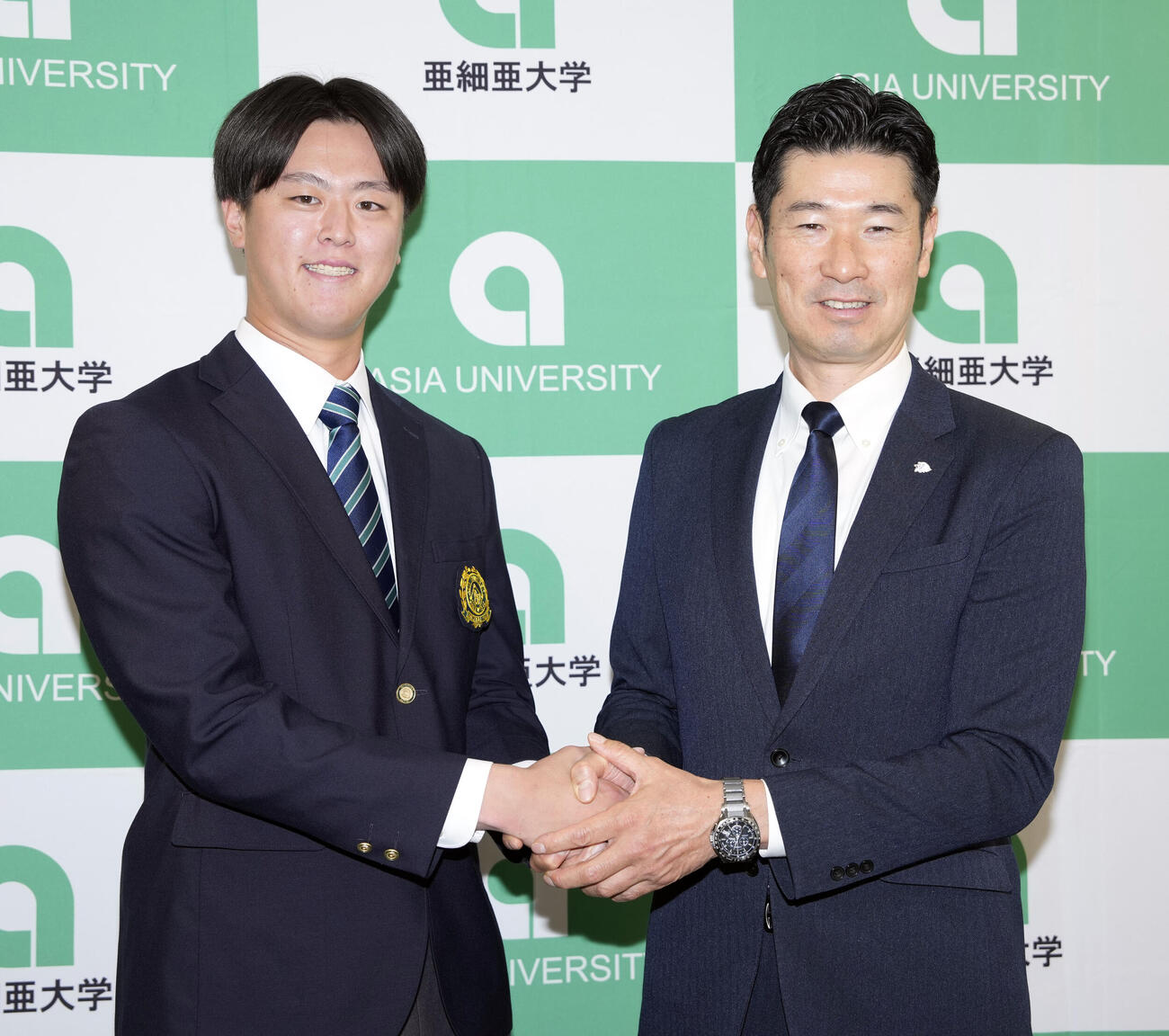 笑顔で写真に納まるドラフト1位の亜大・川尻啓人（左）と西武広池浩司球団本部長（撮影・小島史椰）