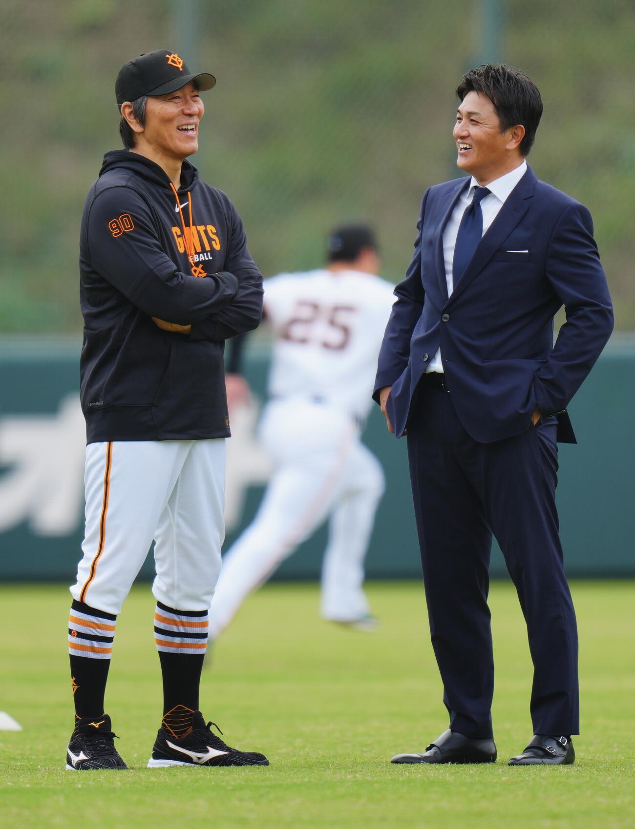 練習中、笑顔で言葉を交わす巨人松井秀喜監督（左）と高橋由伸ヘッドコーチ（撮影・垰建太）