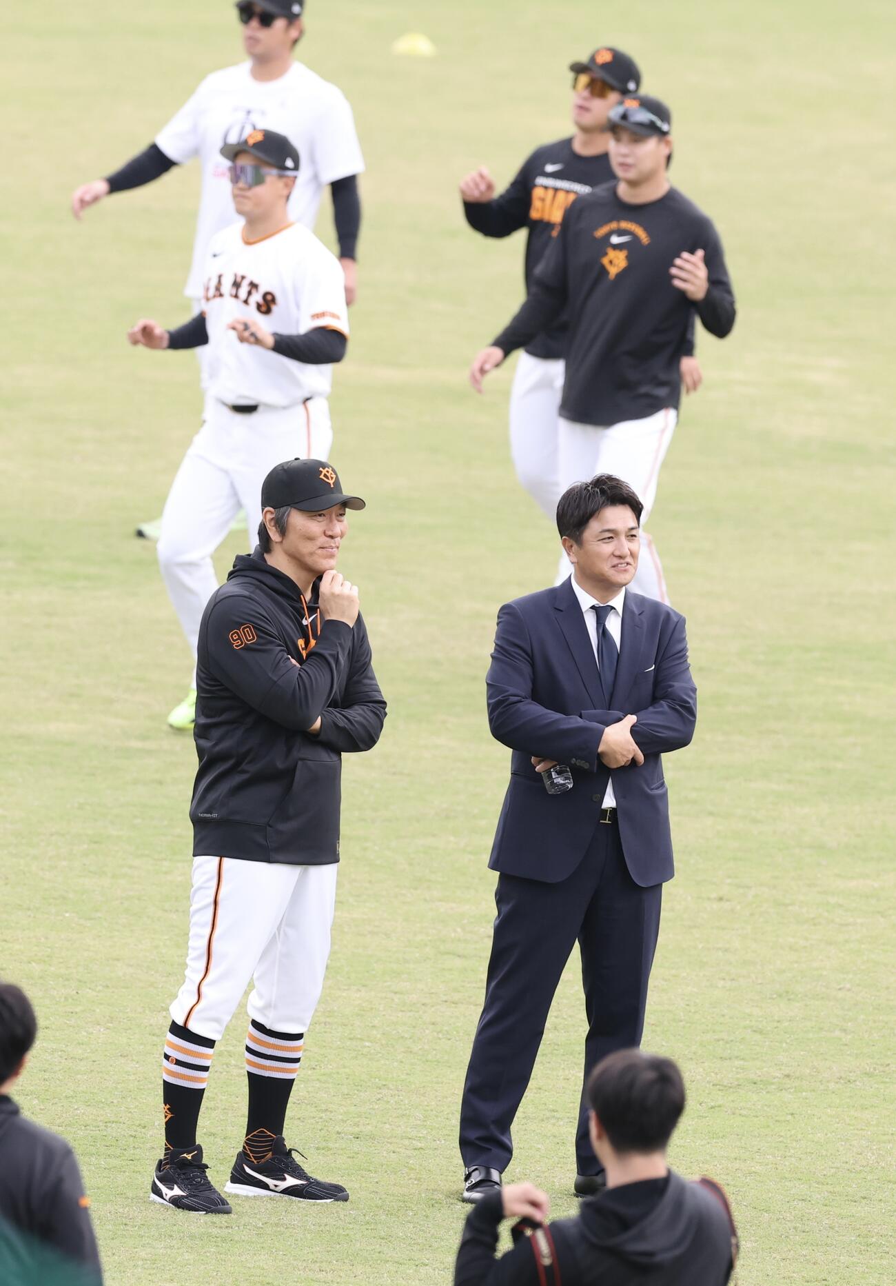 秋季キャンプ初日　練習する選手の中、話し込む巨人松井秀喜監督(左)と高橋由伸ヘッドコーチ(撮影・浅見桂子)2026年10月30日　ジャイアンツ球場